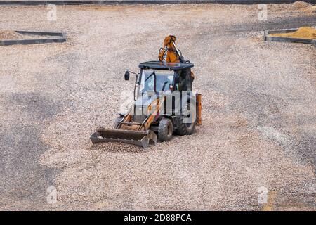 Russie, Kaluga - 27 OCTOBRE 2020 : tracteur avec godet de nivellement de gravier pour la construction de routes. Banque D'Images