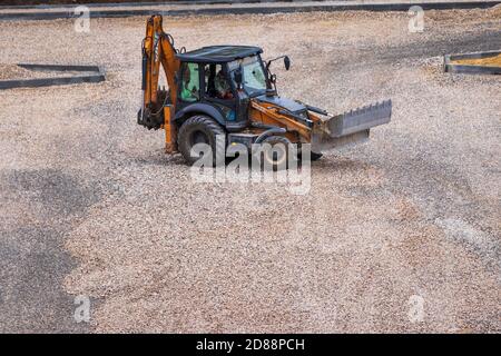 Russie, Kaluga - 27 OCTOBRE 2020 : tracteur avec godet de nivellement de gravier pour la construction de routes. Banque D'Images