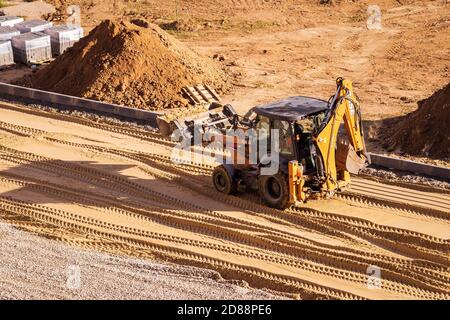 Russie, Kaluga - 27 OCTOBRE 2020 : tracteur avec godet de nivellement de sable pour la construction de routes. Banque D'Images