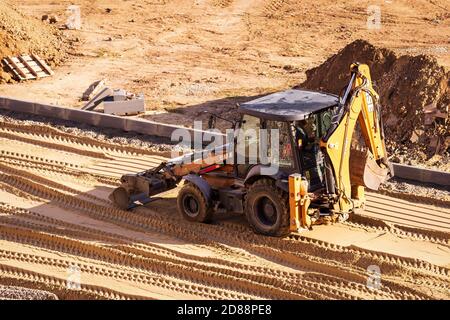 Russie, Kaluga - 27 OCTOBRE 2020 : tracteur avec godet de nivellement de sable pour la construction de routes. Banque D'Images