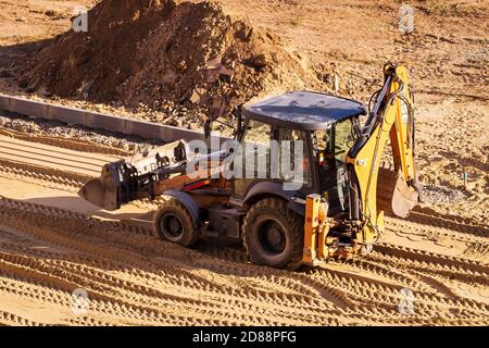 Russie, Kaluga - 27 OCTOBRE 2020 : tracteur avec godet de nivellement de sable pour la construction de routes. Banque D'Images