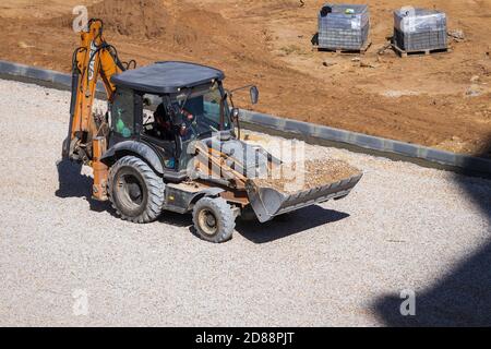 Russie, Kaluga - 27 OCTOBRE 2020 : tracteur avec godet de nivellement de gravier pour la construction de routes. Banque D'Images