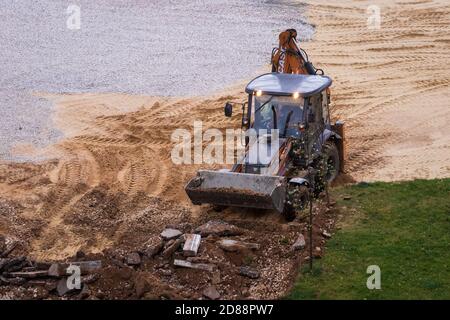 Russie, Kaluga - 27 OCTOBRE 2020 : tracteur brisant l'ancien asphalte avec un godet avant la construction d'une nouvelle route. Banque D'Images