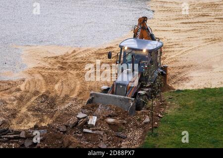 Russie, Kaluga - 27 OCTOBRE 2020 : tracteur brisant l'ancien asphalte avec un godet avant la construction d'une nouvelle route. Banque D'Images