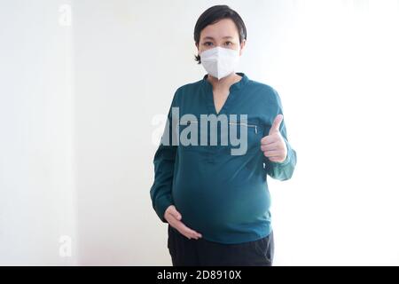 Prise de vue d'une femme enceinte portant un masque médical Banque D'Images