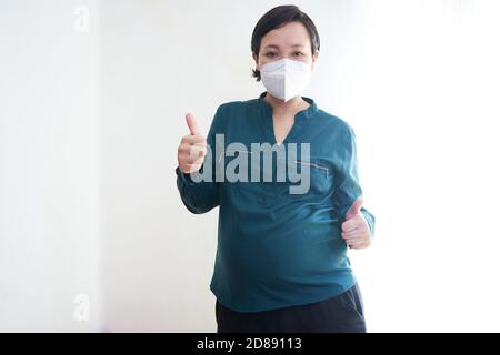 Prise de vue d'une femme enceinte portant un masque médical Banque D'Images