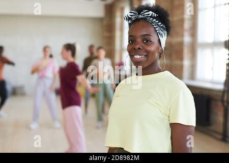 Portrait de la jeune femme africaine souriant à la caméra pendant l'entraînement en studio de danse Banque D'Images