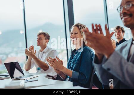 Groupe de professionnels des affaires hommes et femmes se claquant la main dans la conférence. Le public applaudit après un séminaire réussi. Banque D'Images