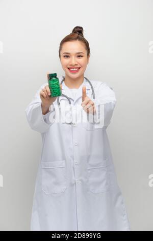 femme heureuse montrant pouce et tenant la bouteille avec des pilules Banque D'Images