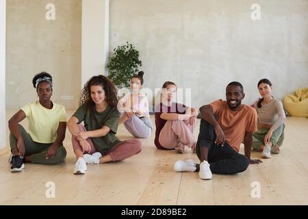 Portrait de jeunes assis sur le sol et regardant à la caméra dans le club de santé Banque D'Images