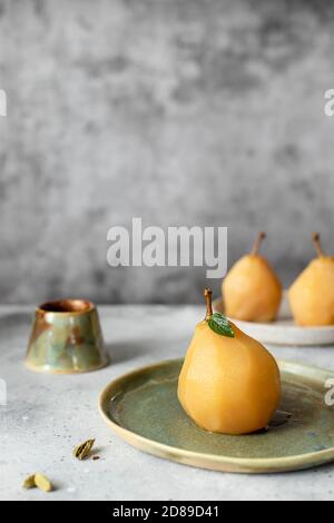 Délicieuse poire dorée pochée à la cannelle et à la cardamome. Fond gris. Banque D'Images