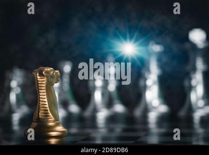 Golden Knight pièces d'échecs face en face d'échecs en argent à bord avec éclat de lumière pour réussir dans la compétition. Strate de direction ou de leadership Banque D'Images