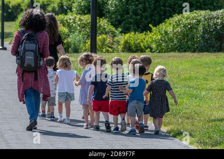Une ligne d'enfants de maternelle suivant leurs enseignants par Georgetown Waterfront Park à Washington DC Banque D'Images