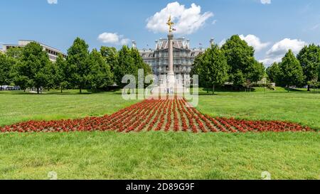 Des rangées de fleurs rouges en forme de numéro 1 pointent vers le monument de la première division de Cass Gilbert, avec l'immeuble Eisenhower en arrière-plan. Banque D'Images