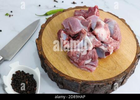 Viande de chèvre ou morceaux de mouton ou d'agneau frais et crus. Préparation du curry de mouton indien. Épice à l'arrière-plan comme des bâtons de cannelle, poudre de piment rouge, Banque D'Images