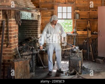 Un guide costumé montre comment façonner un bar en fer lors de la reconstruction en 2009 de la 18e boutique C. Blacksmith à Mount Vernon, à George Washington. Banque D'Images