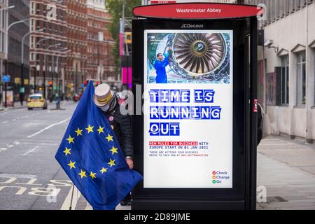 Londres, Royaume-Uni. 28 octobre 2020. Steve Bray, un manifestant contre le Brexit de la SODEM à côté d'un panneau lié au Brexit à un arrêt de bus devant le Département des affaires, de l'énergie et de la stratégie industrielle de Westminster. Michel Barnier, chef de la Task Force pour les relations avec le Royaume-Uni de la Commission européenne, assiste à des réunions à l'intérieur. Credit: Stephen Chung / Alamy Live News Banque D'Images