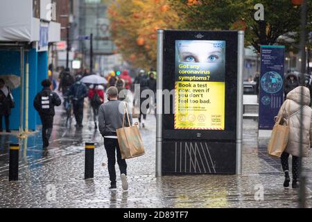 Les gens dehors et sur la pluie dans le Tier 3 Manchester. Banque D'Images