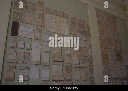 Brescia, Italie -26 juin 2019 : la collection d'inscriptions romaines insérées dans les murs reconstruits du parc archéologique de Brescia Romana de Brixia. Nu Banque D'Images