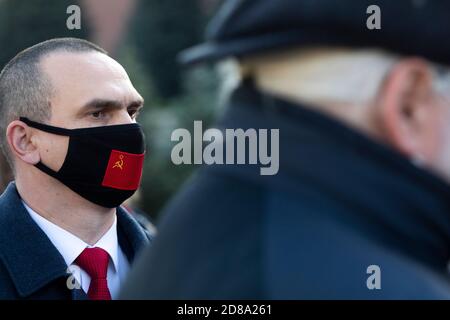 Moscou, Russie. 28 octobre 2020 UN homme portant un masque facial avec le drapeau de l'URSS se réunit sur la place Rouge avec d'autres partisans du parti communiste pour marquer le 102e anniversaire de Komsomol, ou la Ligue de jeunes communistes léninistes de toute l'Union, l'organisation de jeunesse communiste de l'ère soviétique, à Moscou, en Russie Banque D'Images