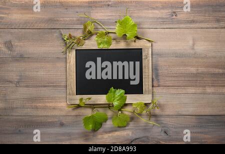 Tableau noir avec décoration de feuilles de vigne vertes Banque D'Images