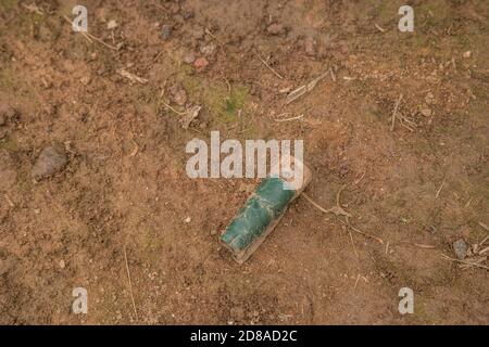 Ancienne carapace de fusil rouillé usagée et vide de mise au rebut une arme à feu posée sur le sol sale avec le plastique manchon écrasé Banque D'Images