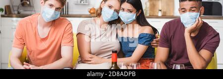 récolte horizontale de tristes amis multiculturels dans les masques médicaux ayant partie pendant la quarantaine Banque D'Images