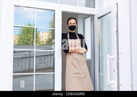 propriétaire de café masculin en tablier et masque de protection Banque D'Images