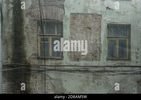 Vieux mur de briques. Fermé avec un filet en plastique pour des raisons de sécurité. Maison du XIXe siècle abandonnée dans le centre-ville. Banque D'Images