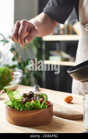 Gros plan du plat de cuisine du chef avec de la viande frite au table dans la cuisine Banque D'Images