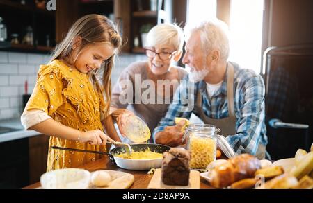 Grandchildrens avec plaisir les filles le petit-déjeuner avec ses grands-parents Banque D'Images