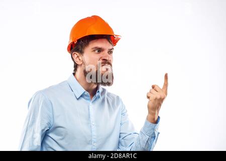 Homme en colère dans orange casque dur industrie travail insatisfaction pantacourt vue Banque D'Images