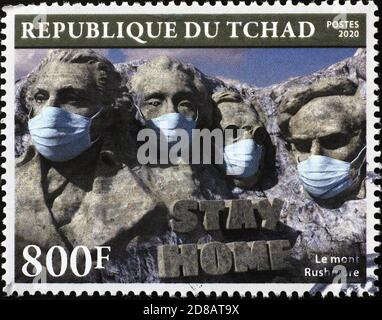 Les présidents du Mont Rushmore avec des masques antivirus sur le timbre. Image des statues portant le masque. Banque D'Images