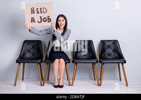 Portrait d'elle belle attirante désespéré femme dirigeant le directeur assis dans un fauteuil tenant une affiche à la recherche de l'économie de l'emploi criant aidez-moi s'il vous plaît Banque D'Images