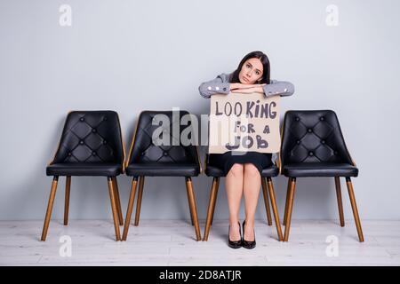 Portrait d'elle belle attirante ennuyé déprimé lady tiré le directeur financier des ventes est assis sur le fauteuil et tient l'affiche promotionnelle recherche d'emploi Banque D'Images