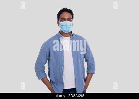 Homme indien portant un masque médical isolé. Chemise homme en bleu avec masque médical. Santé, virus, concept médical Banque D'Images