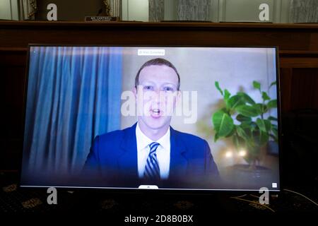 Mark Zuckerberg, PDG de Facebook, apparaît sur un écran lorsqu'il témoigne à distance lors du comité sénatorial du commerce, des sciences et des transports, qui a entendu « la grande immunité de la Section 230 permet un mauvais comportement Big Tech ? », à Capitol Hill à Washington, DC, Etats-Unis, le 28 octobre 2020. Le PDG de Twitter Jack Dorsey, le PDG d'Alphabet Inc. Et de sa filiale Google LLC, Sundar Pichai, et le PDG de Facebook Mark Zuckerberg ont tous témoigné pratiquement à l'audience. L'article 230 de la Loi sur la décence des communications garantit que les entreprises de technologie ne peuvent pas être intentées pour du contenu sur leurs plates-formes, mais le ministère de la Justice Banque D'Images