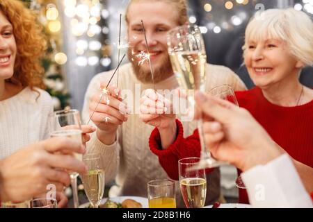 Champagne en verre et lumière étincelante entre les mains des gens Banque D'Images