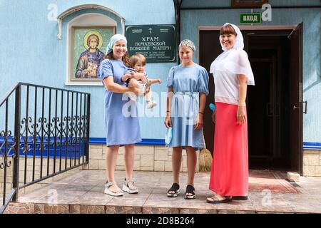 Davlekanovo, Russie - vers août 2020 : les femmes russes se tiennent sur le porche de l'église orthodoxe avant le baptême des tout-petits. Godmather avec godfaughter, la mère wi Banque D'Images