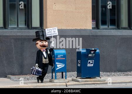 Minneapolis, Minnesota. Les employés des postes se rassemblent pour exiger que le Congrès agisse pour sauver le service postal. M. moneyBags portant un panneau de protestation. Banque D'Images