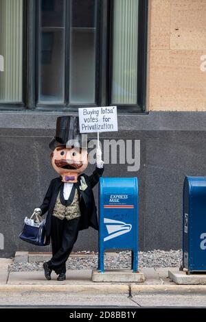 Minneapolis, Minnesota. Les employés des postes se rassemblent pour exiger que le Congrès agisse pour sauver le service postal. M. moneyBags portant un panneau de protestation. Banque D'Images