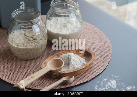 entrées de levain bio naturel : entrées de seigle pétillant et de blé fraîchement fermentées dans des pots en verre prêts à l'emploi pour faire du pain de levain Banque D'Images