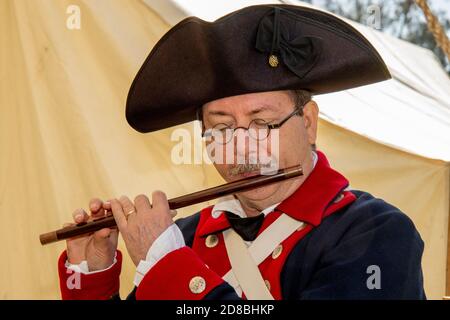 Vêtu d'un uniforme de l'armée continentale lors d'une reconstitution de la guerre d'indépendance américaine dans un parc de Huntington Beach, CA, un acteur déguisé joue la fife. Banque D'Images