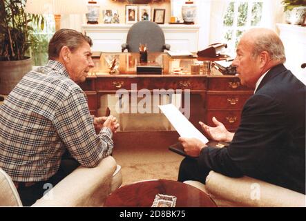 Dans cette photo publiée par la Maison Blanche, le secrétaire d'État américain George P. Shultz, à droite, informe le président américain Ronald Reagan, à gauche, des derniers développements de Beyrouth, au Liban, dans le bureau de Michael K. Deaver, assistant du président et chef de cabinet adjoint, À la Maison Blanche à Washington, DC le 18 septembre 1982. Crédit obligatoire : Karl Schumacher/Maison Blanche via CNP | utilisation dans le monde entier Banque D'Images