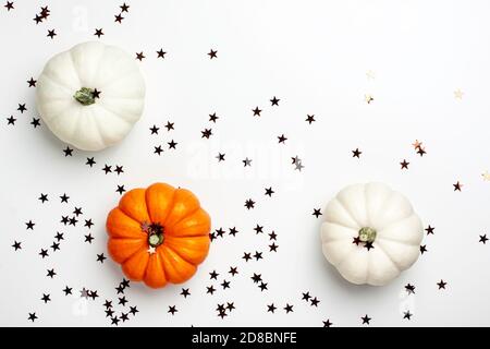 Pose plate de mini-potiron décoratif blanc et orange et étoiles brunes sur fond clair d'en haut. Halloween et Thanksgiving carte de voeux vacances Banque D'Images