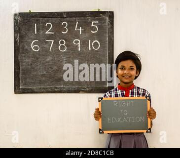 Durgapur/ Inde - octobre 15,2020. Une fille de l'école primaire qui tient un conseil vert a écrit « droit à l'éducation » dans une classe. Une image de concept. Banque D'Images