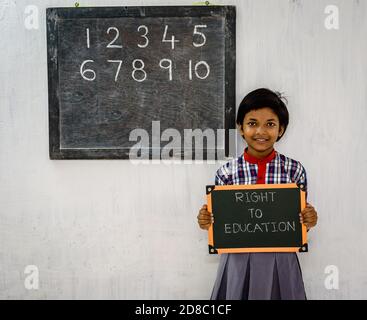 Durgapur/ Inde - octobre 15,2020. Une fille de l'école primaire qui tient un conseil vert a écrit « droit à l'éducation » dans une classe. Une image de concept. Banque D'Images