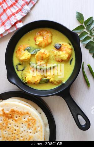 Crevettes jaunes ou curry de crevettes servies avec Amboli ou Soft Dosa. Crevettes cuites dans du lait de coco aux épices douces. Curry thaïlandais jaune de crevettes. Curry de Goan. Banque D'Images