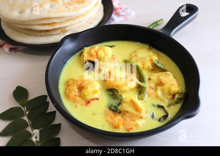 Crevettes jaunes ou curry de crevettes servies avec Amboli ou Soft Dosa. Crevettes cuites dans du lait de coco aux épices douces. Curry thaïlandais jaune de crevettes. Curry de Goan. Banque D'Images