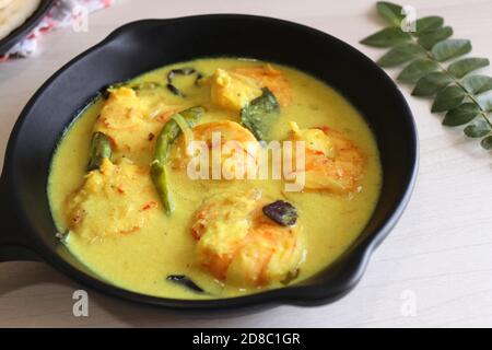 Crevettes jaunes ou curry de crevettes servies avec Amboli ou Soft Dosa. Crevettes cuites dans du lait de coco aux épices douces. Curry thaïlandais jaune de crevettes. Curry de Goan. Banque D'Images